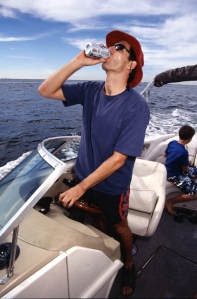 A few things to note in this image: drinking while operating a boat and a child not wearing a life jacket. It is against Oregon boating law for an operator to be impaired and for children under 13 to not be wearing a properly fitting, US Coast Guard approved life jacket. 